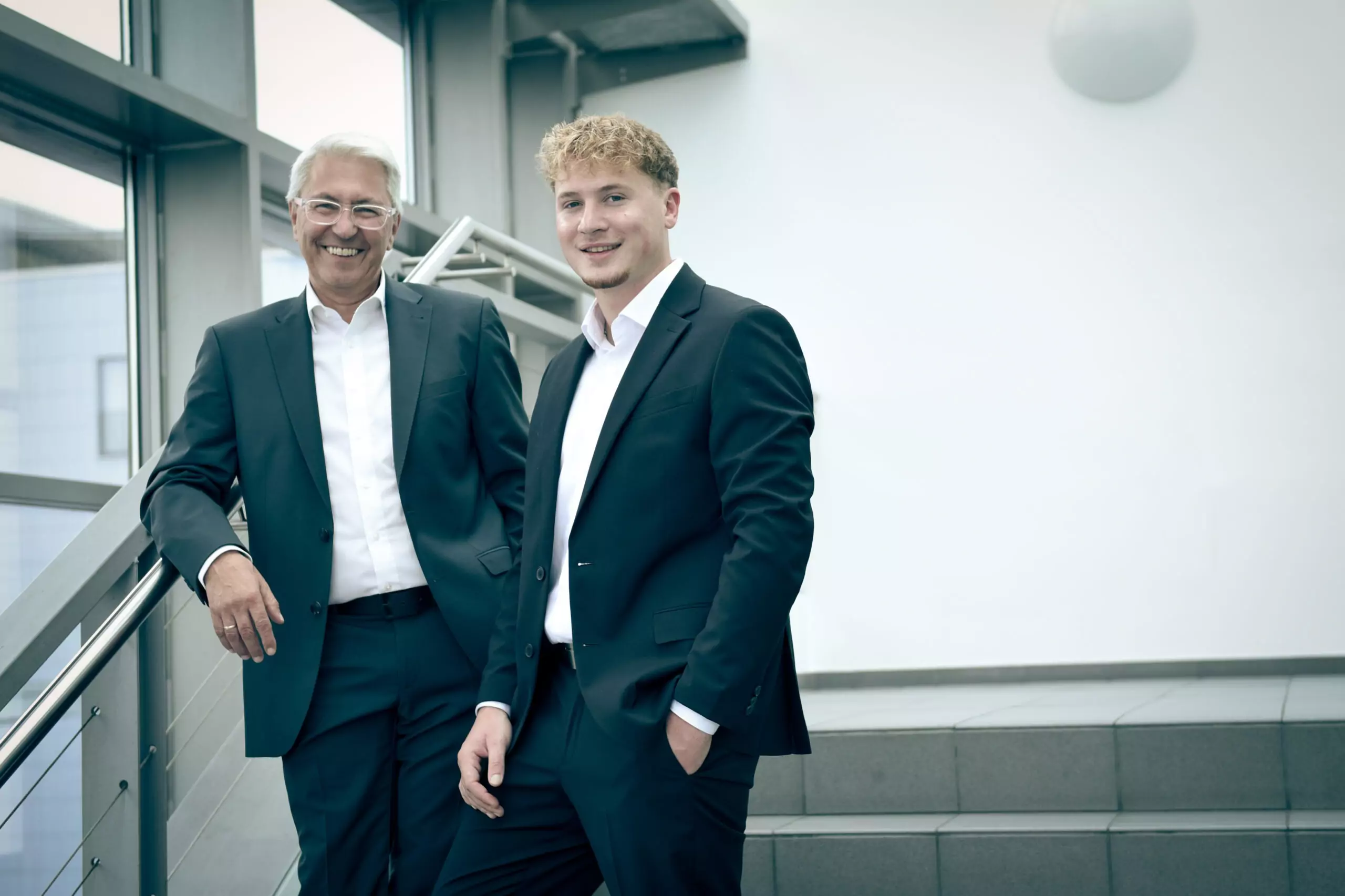 Inhaber Makler Portrait - Michael Beck und Erik Krieger stehen auf einer Treppe